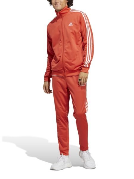 Adidas oranžinis vyriškas sportinis kostiumas su baltomis juostelėmis – klasikinio kirpimo, iš trikotažo, su šoninėmis kišenėmis. M 3s Tracksuit Basics IC6786