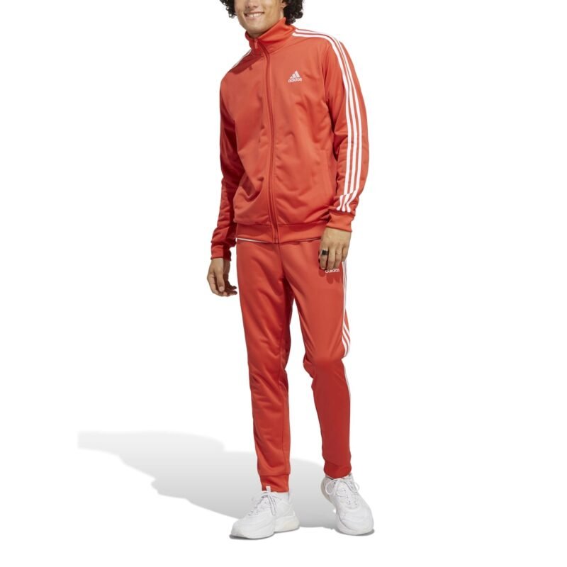 Adidas oranžinis vyriškas sportinis kostiumas su baltomis juostelėmis – klasikinio kirpimo, iš trikotažo, su šoninėmis kišenėmis. M 3s Tracksuit Basics IC6786