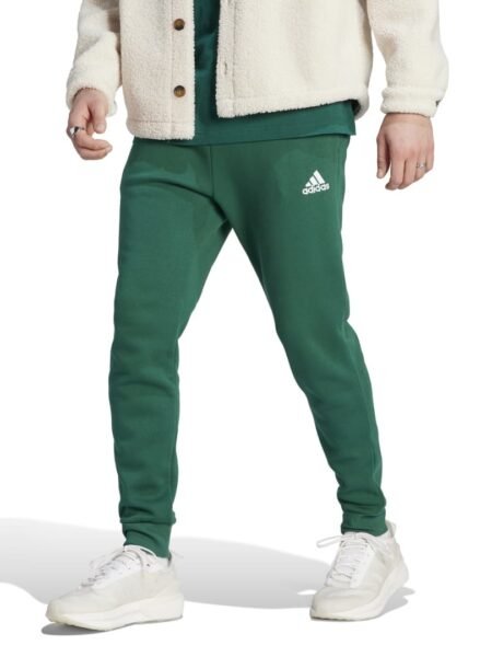 Adidas Essentials vyriškos žalios sportinės kelnės IJ8892 su siaurėjančiu kirpimu, kišenėmis ir elastingais manžetais.