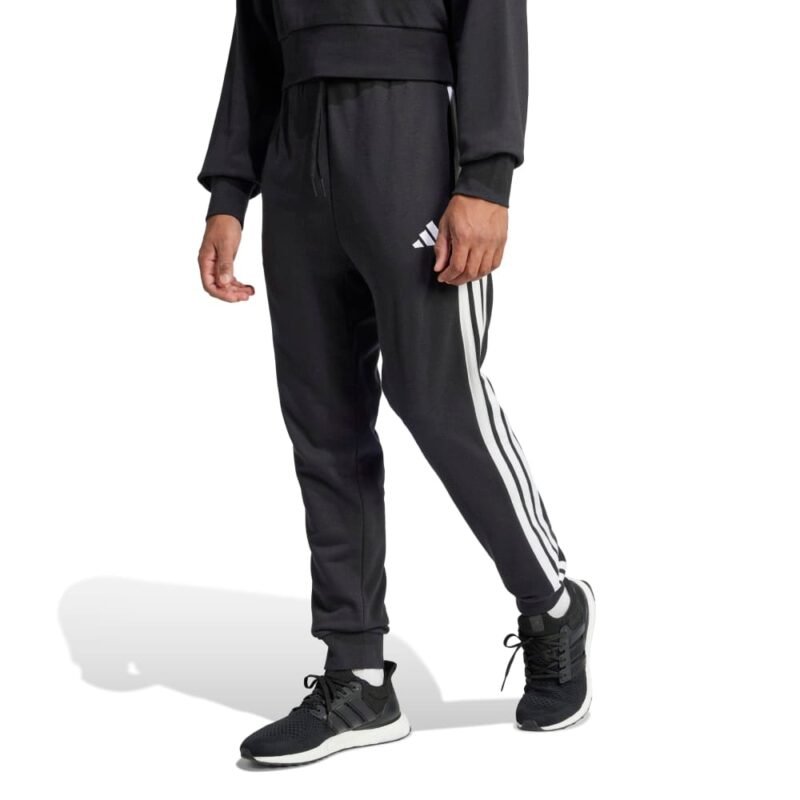 Adidas vyriškos juodos treninginės kelnės JD1881 su baltomis šoninėmis juostelėmis ir siaurėjančiu siluetu.