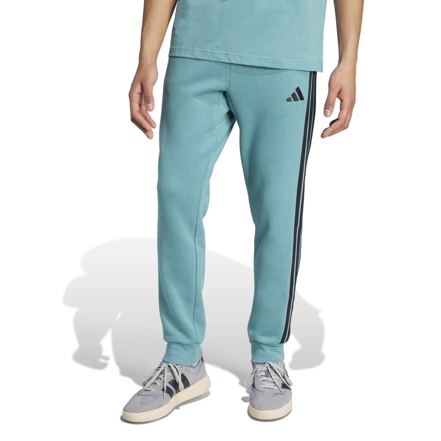 Adidas vyriškos sportinės kelnės Essentials 3-Stripes TC Fleece Pants JX0711 – šviesiai žalios fleece kelnės su juodomis juostelėmis.